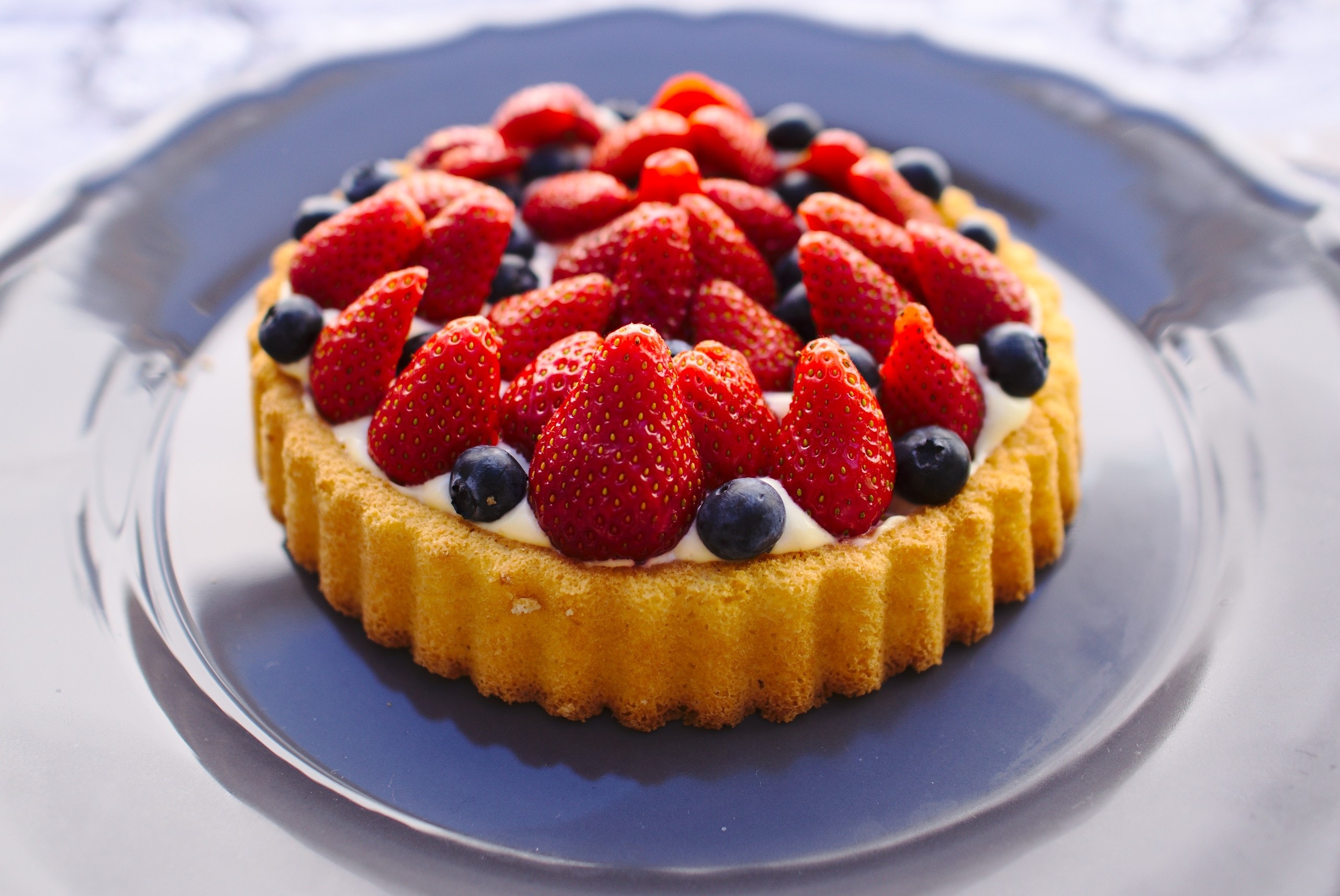 Vanilla cake with blueberries and strawberries on top